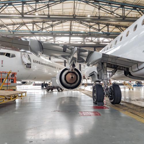Passenger airplane on maintenance repair check in airport hangar.