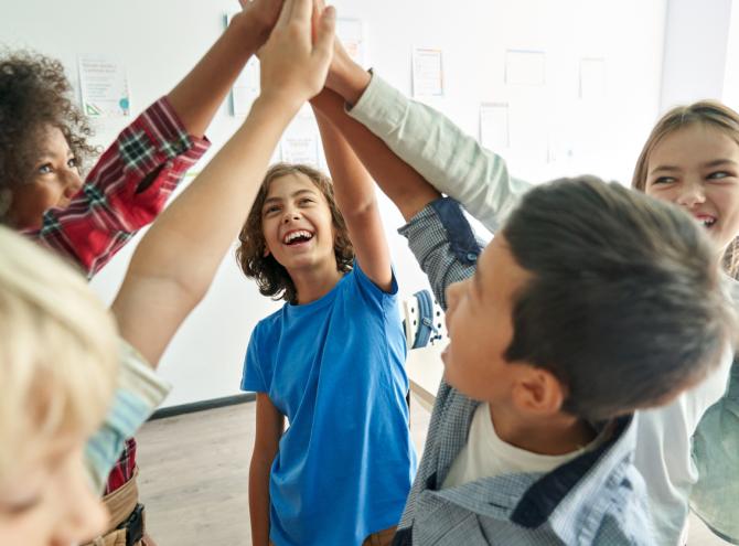 Kids high-fiving in classroom 